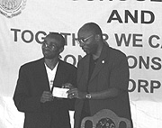 Secretary General of RDGN Ismael Buchanan and u2018One Dollar Campaignu2019 coordinator Robert Masozera display the cheque (Photo  C.Kwizera)