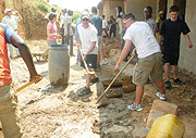 Guests to the Kigali Festival help plaster a survivor's home in Kimironko (Photo P. Gathoni)