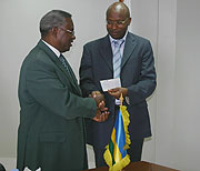 Defence Minister Marcel Gatsinzi hands the 41-million cheque to Masozera as the ministry's contribution towards the One Dollar Campaign (Photo F. Goodman)