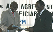 HIDA Director Charles Karake hands a document to Governor  Francois Kanimba after the signing of the institutional support agreement  (Photo bya H. Goodman