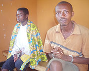 Dorocella Musabyimana (R) and Darius Mwizerwa (handcuffed) at the police station. Photo S Rwembeho