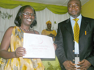 Odette Kayirere displays the award, on her right is the CAFOD representative. (Photo: S. Rwembeho)