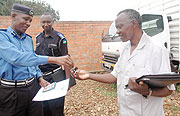 Tony Kuramba of the national police hands over the keys of the recovered vehicle to his Kenyan counterpart, Simon Ondego