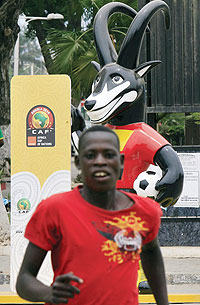 A man runs by Palaquinha, the official mascot of the 2010 Africa Cup of Nations in Angola. The tournaments gets underway this afternoon with the hosts, Angola taking on Mali in the opening game. (Net photo)