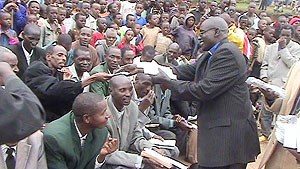 Pastor Silas Twagirumukiza distributing condoms to fellow religious leaders at a function to senstise the community yesterday. (Photo: S. Nkurunziza)