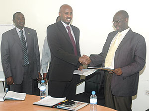 Outgoing MHC Board Chairman, Venuste Karambizi, hands over instruments of power to his successor, Arthur Asiimwe, yesterday (Photo FGoodman)