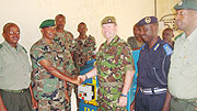 UK Defence Attachu00e9, Lt. Col. Simon Etherington, officially hands over the equipment to Lt. Col. Innocent Kabandana, as other officers look on