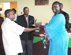 Apollo Munanura (C)  gives representatives of Oxford University Press an award for Best Exhibitor. (Photo by Allan B.)