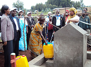 Minister Collette Ruhamya, extreme left, accompanied by the district Mayor J Damascene Ndagijimana at Bikingi water tap.photo B Mukombomzi