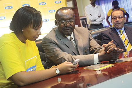 Governor Francios Kanimba recieves a demonstration recently, on how Mobile Money works. Looking on is MTN CEO Khaled Mikkawi (Photo/ D. K. Musoke)