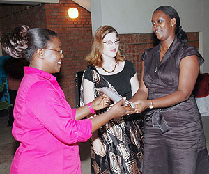 Minister of Gender and Family Promotion Dr. Jeanne du2019Arc Mujawamariya (L) presents a certificate to one of the participants, Natasha Kabandana. (Photo; J. Mbanda)