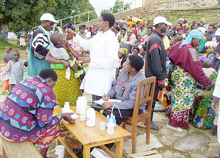 A nurse administers vitamin A tablet to a child at Nyarutarama vaccination site on Wednesday. 