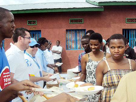 Tigo Rwanda  staff serving food to orphans of Itetero Association.(Photo D.Sabiiti)