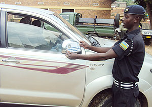 WELCOME MOVE: A police officer placing  a sticker on a vehicle as part of the commemoration activies. Most residents have welcomed the activities. 