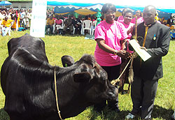 The Minister of Gender, Jeanne du2019Arc Mujawamariya hands over a heifer to one of the guardians. (Photo R. Mugabe)