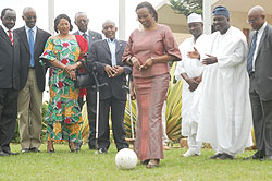 Speaker Rose Mukantabana kicks a ball to mark Rwandau2019s joining of parliamentary network on MDGs. Looking on are Rwandan and  Nigerian MPs