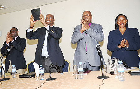 Local Government Minister James Musoni (2nd Left) displays a bible which was given to him by the church leaders. (Photo J Mbanda)