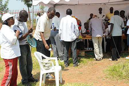 A man picks a piece of paper bearing what will be his plot's number at the land allocation in Kabuga yesterday. (Photo J Mbanda)