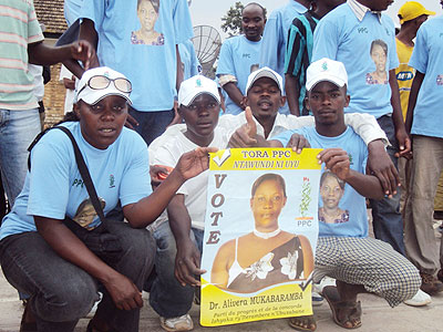 Supporters pose with their candidateu2019s poster. (Photo: S. Rwembeho)