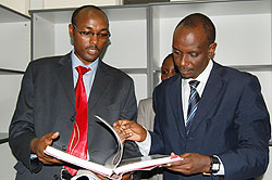 Doctor Emmanuel Nkusi shows  Minister Sezibera one of the books available in the newly opened neurosurgical library(Courtesy Photo)