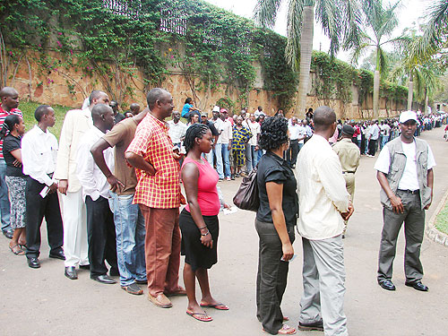 Rwandans in Uganda queue to cast their votes yesterday morning, as a Ugandan Police officer controls the crowd.  (Photo E Kabeera)