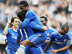 Didier Drogba is mobbed by teammates after completing his hat-trick. (Net photo)