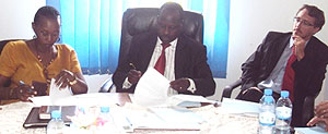 Stella Ford Mugabo (L) and Dr. Eugene Ndabaga (C), sign while BTC representative, Patrick Gaudissart looks on (Photo D.Ngabonziza)