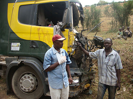 NARROW ESCAPE:  A Driver (L) and his assistant (R) stand in front of their truck (Photo S. Rwembeho)