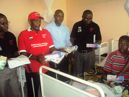 Dr. Jean Claude Ndagijimana (3rd R) joins GCAP officials in donating clothes to newly born children. In cap is MP Pierre Claver Rwaka (Photo S. Rwembeho)