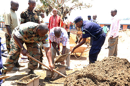 (L-R) Lt Colonel Happy Ruvusha, Kicukiro District Mayor Paul Ndamage and the District Police Commander Sam Romanzi making bricks for classrooms yesterday (PhotoT.Kisambira)