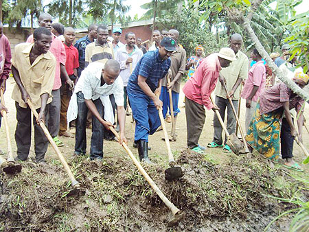 LEADING BY EXAMPLE: Karongi Mayor Bernard Kayumba (centre) leading residents in  community work to fix the Karongi-Rubavu road. (File  photo)