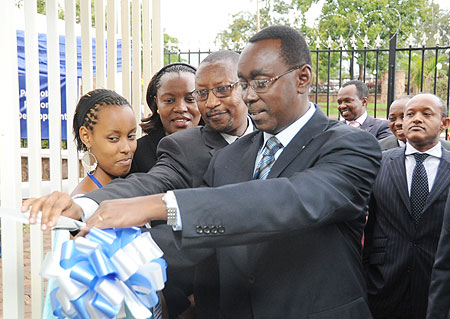 Prime Minister Bernard Makuza cuts the tape as Finance Minister John Rwangombwa, and the Director General of EADB, Vivienne Apopo, look on Photo T.kisambira