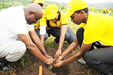 Paul Mugemangango, the MTN Senior Legal and Corporate Affairs Manager (L) planting trees with MTN staff