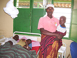 Musanabera standing by two of her children hospitalised at Byumba Hospital on Sunday. Photo A.Gahene