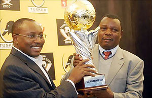 Musonye (r) holds the brand new Cecafa Challenge Cup trophy with sponsoru2019s representative Seni Adetu