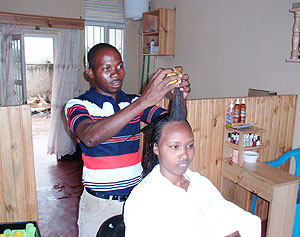 Experienced Shadrack Ntare works on a customers hair at Imanzi Saloon in Kimironko market.(Photo M.Kirui)