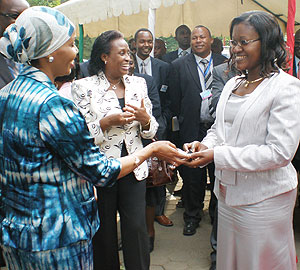 Hon. Monica Mukaruriza receives keys from, Hafsa Mosi in Arusha on Tuesday as EAC Deputy Secretary General, Beatrice Kiraso looks on.