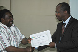 Tanzaniau2019s Deputy Minister for Transportation, Athuman Mfutakamba hands a certificate of participation of John Gara after the meeting in Mwanza (Photo G Muramira)