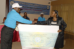 The Mayor of Nyabihu, Jean Damaciene Ndajimana receiving cheque of Rwf1.3 million after his district emerged the best (Courtsey Photo).