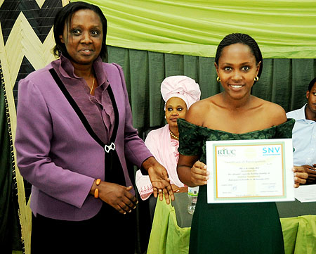 Hope Mukantishi displays her certicate after the course in customer care. Looking on is SNV's Antoinette Uwimana (Photo T Kisambira)