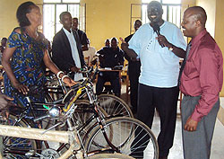 Minister Karugarama handing over a bicycle to a female mediator in Kiramuruzi sector as Gatsibo district mayor, Anselme Rurangw