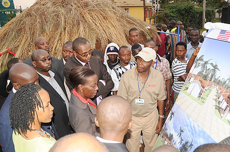 Foreign Affairs Minister Louise Mushikiwabo (C) being shown pictures of modern housing in contrast to Nyakatsi in the background. She was launching the Diaspora Expo on Wednesday (Photo J Mbanda)