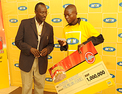 Innocent Bizimana gladly recieves his Rwf 1million cheque from MTN (File Photo)