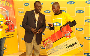 Andrew Rugege, MTNu2019s COO after handing over a cheque to one of the winners, Innocent Bizimana,  recently (File Photo)