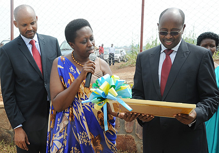 L-R; RALGA Secretary General Theogene Karake, Chairperson Aisa Kirabo and Minister of Local Government James Musoni look at a gift presented to the Minister. (Photo J Mbanda)