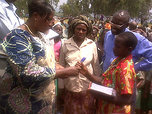 Joy Basinga of AVP handing out scholastic materials to one of the orphans. (Photo Innocent Ninsiima)