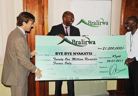 Sven Piedriet Bralirwa MD, presenting a dummy check to Robert Masozera and RDGN's Dr. Ismael Buchanan yesterday (Photo T.Kisambira)