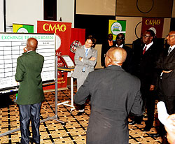 Celestin Rwabukumba of RSE conducting trading as Prime Minister Bernard Makuza and the Minister of Finance and Economic Planning, John Rwangombwa look on (PhotoT. Kisambira)