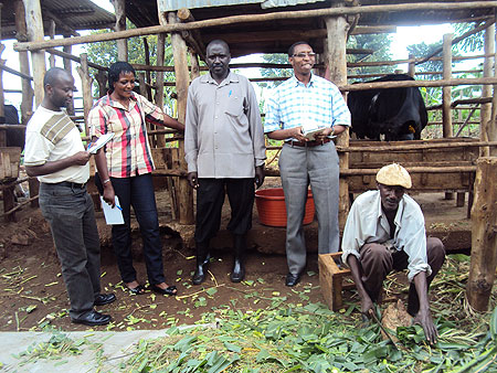 Etienne Kabera (C) a successful farmer talking to Send A Cow officials who visited his farm recently. (Photo S. Rwembeho).