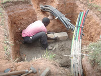 A Man lays Fibre Optic cables. EALA legislators will be touring such projects (File Photo)